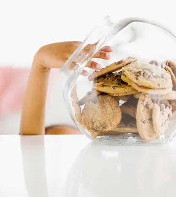 a person holding a glass container filled with cookies at Country Inn & Suites by Radisson, Greeley, CO in Greeley