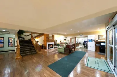 a large living room with a staircase and a living room at Country Inn & Suites by Radisson, Greeley, CO in Greeley