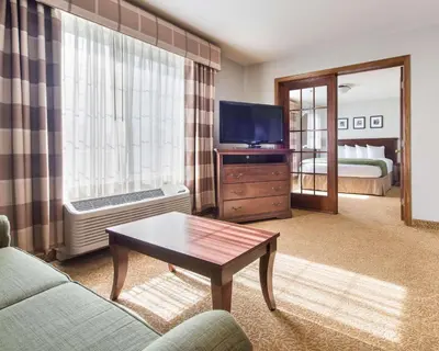 a living room with a couch and a tv at Country Inn & Suites by Radisson, Greeley, CO in Greeley