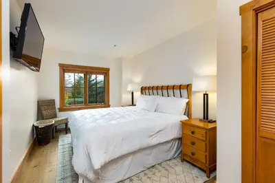 a bedroom with a white bed and a television at 8577 Expedition Station Condo in Keystone