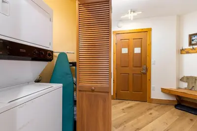 a kitchen with a refrigerator and a wooden door at 8577 Expedition Station Condo in Keystone