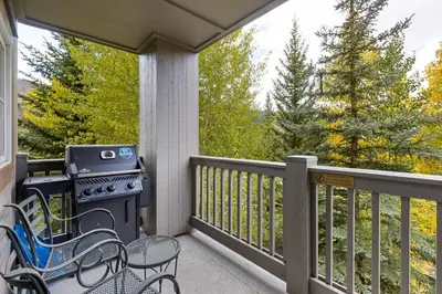 a screened in porch with a stove and chairs at 8577 Expedition Station Condo in Keystone