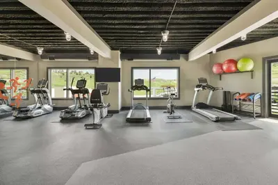 a gym with many exercise equipment in a room at Origin Red Rocks, a Wyndham Hotel in Golden