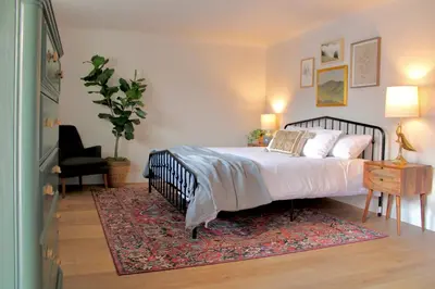 a bedroom with a large bed and a rug at Kinnikinnik Motor Lodge in Estes Park