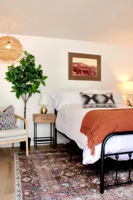 a bedroom with a bed and a plant and a chair at Kinnikinnik Motor Lodge in Estes Park