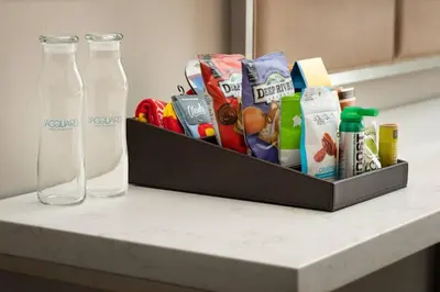 a counter with two glass bottles on top of it at The Jacquard, Autograph Collection in Denver