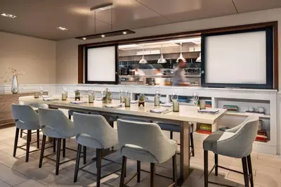 a restaurant with a long table and chairs at The Jacquard, Autograph Collection in Denver