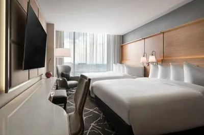 a hotel room with two beds and a flat screen tv at The Jacquard, Autograph Collection in Denver