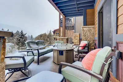a patio with chairs and a table with snow on it at River Run Townhome RR51 in Keystone