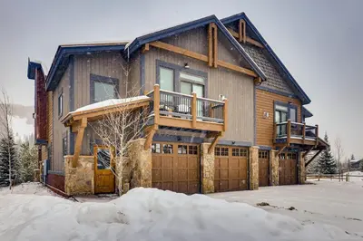 a large wooden house with a deck in the snow at River Run Townhome RR51 in Keystone