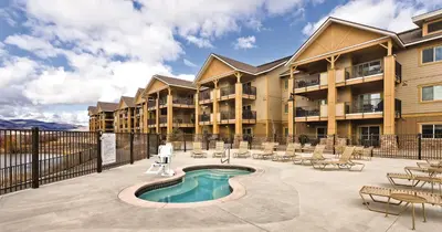 a large apartment building with a pool and chairs at WorldMark Granby - Rocky Mountain Preserve in Granby