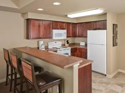 a kitchen with a white refrigerator and wooden cabinets at WorldMark Granby - Rocky Mountain Preserve in Granby