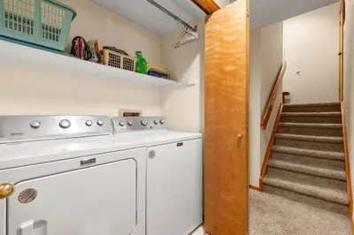 a laundry room with a washer and dryer and stairs at Mountainside 523 Home in Frisco
