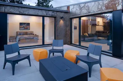 a patio with chairs and tables and a couch at Timberline Haus Home in Nederland