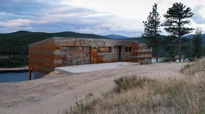 a brick building on the side of a river at Timberline Haus Home in Nederland