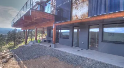 a modern house with a balcony and glass doors at Timberline Haus Home in Nederland