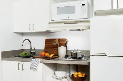 a white kitchen with a sink and a microwave at InTown Suites Extended Stay Denver - Englewood in Englewood