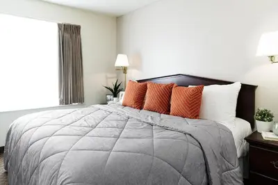 a bedroom with a large bed with orange pillows at InTown Suites Extended Stay Denver - Englewood in Englewood