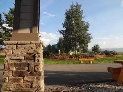 a stone pillar with a bench in a park at Littletree Inn in Granby