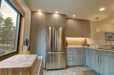 a kitchen with a stainless steel refrigerator and wooden cabinets at 732B Meadow Creek Townhouse in Frisco