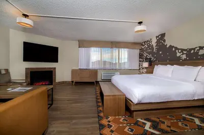 a hotel room with a bed and a fireplace at Holiday Inn Estes Park by IHG in Estes Park