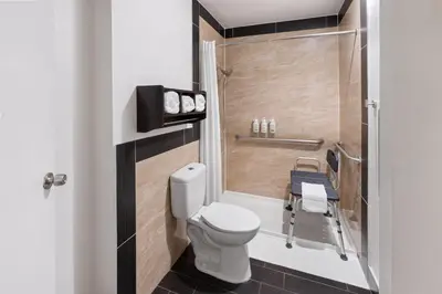 a small bathroom with a toilet and a shower at La Quinta Inn & Suites by Wyndham Fort Collins, Colorado in Fort Collins