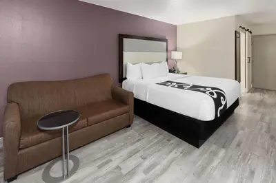 a hotel room with a bed and a couch at La Quinta Inn & Suites by Wyndham Fort Collins, Colorado in Fort Collins