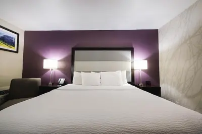 a hotel room with a large bed and two lamps at La Quinta Inn & Suites by Wyndham Fort Collins, Colorado in Fort Collins