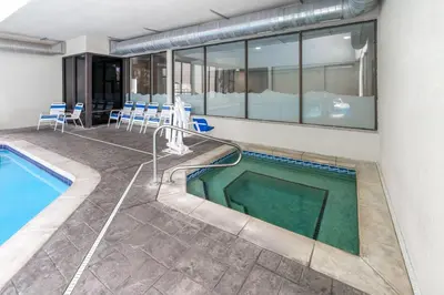 a pool in a building with chairs and a swimming pool at La Quinta Inn & Suites by Wyndham Fort Collins, Colorado in Fort Collins