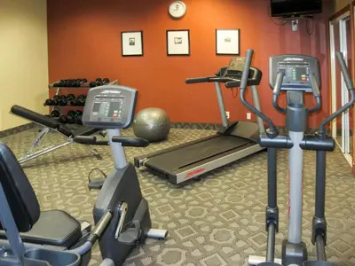 a gym with two exercise bikes and a treadmill at Clarion Inn in Fort Collins