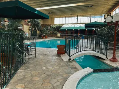 a swimming pool with a bridge in a building at Clarion Inn in Fort Collins