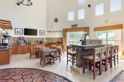 a restaurant with a bar with chairs and a kitchen at Best Western Kiva Inn in Fort Collins