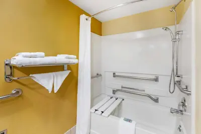 a bathroom with a tub and a toilet and towels at Best Western Kiva Inn in Fort Collins