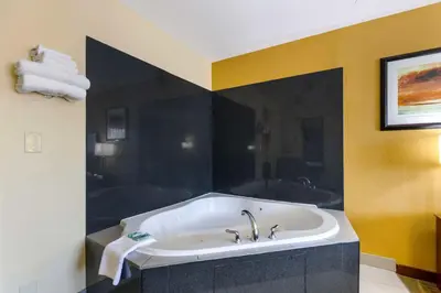 a large bath tub in a bathroom with yellow walls at Best Western Kiva Inn in Fort Collins
