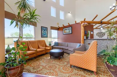 a lobby with couches and chairs and plants at Best Western Kiva Inn in Fort Collins