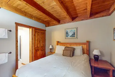 a bedroom with a large bed and wooden ceilings at Lodgepole Landing in Silverthorne