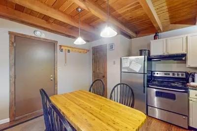 a kitchen with a wooden table and a refrigerator at Lodgepole Landing in Silverthorne