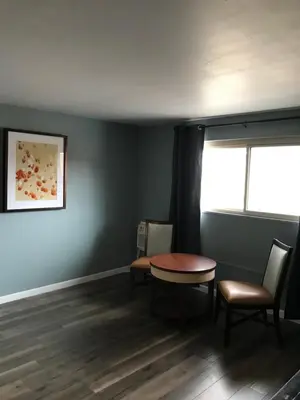 a room with a table and chairs and a window at Lamplighter Motel in Longmont