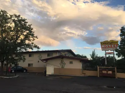 a motel with a sign and a parking lot at Lamplighter Motel in Longmont