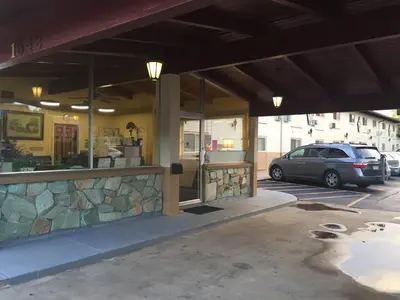 a building with a car parked in a parking lot at Lamplighter Motel in Longmont