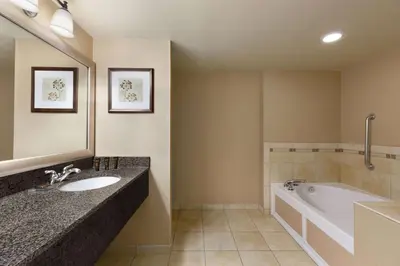 a bathroom with a tub and a sink and a bath tub at Wingate by Wyndham Denver Tech Center in Greenwood Village