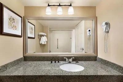 a bathroom with a sink and a large mirror at Wingate by Wyndham Denver Tech Center in Greenwood Village