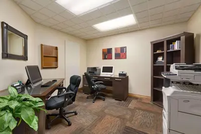 an office with a desk with two computers and chairs at Wingate by Wyndham Denver Tech Center in Greenwood Village