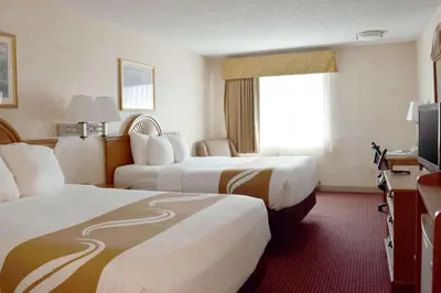 a hotel room with two beds and a television at Quality Inn Louisville - Boulder in Louisville