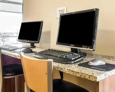 a desk with a computer monitor and a keyboard and mouse at Quality Inn Louisville - Boulder in Louisville