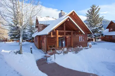 a log cabin in the snow with snow on the ground at Rams Horn Village Resort in Estes Park