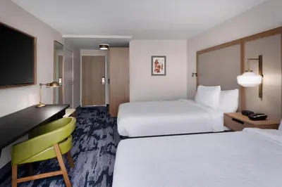a hotel room with two beds and a desk at Fairfield Inn & Suites Boulder in Boulder