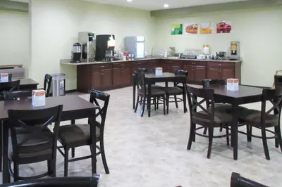 a restaurant with tables and chairs and a kitchen at Quality Inn Longmont in Longmont