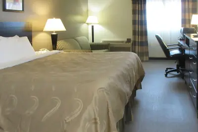 a hotel room with a large bed and a desk at Quality Inn Longmont in Longmont