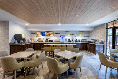 a restaurant with tables and chairs and a kitchen at Comfort Suites Golden West on Evergreen Parkway in Evergreen